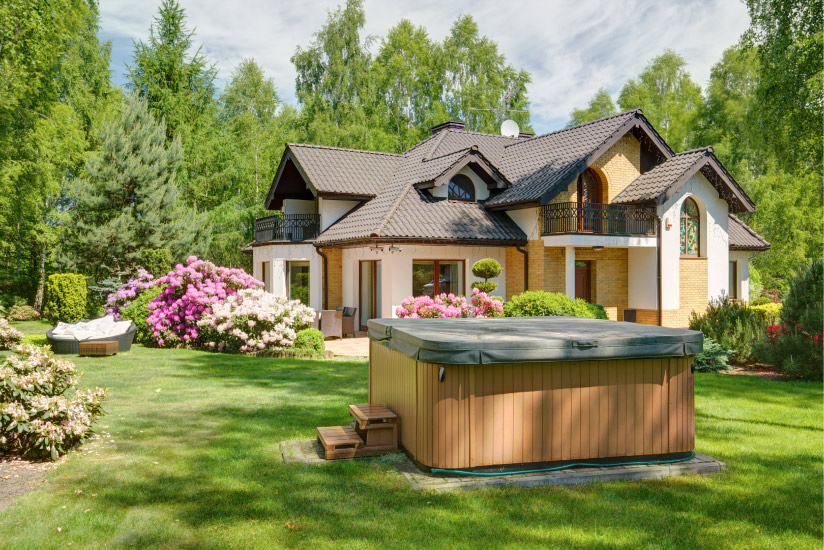 A two story home with a hot tub in yard