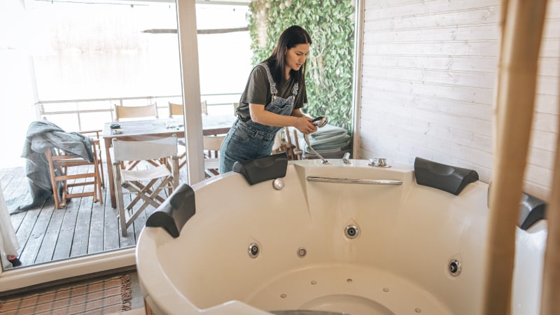 A woman cleaning her hot tub before moving it